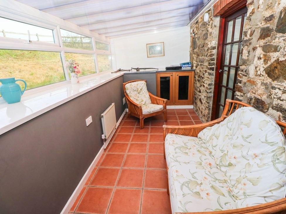 A conservatory with a vase on a windowsill at Coedllys Uchaf Cottage