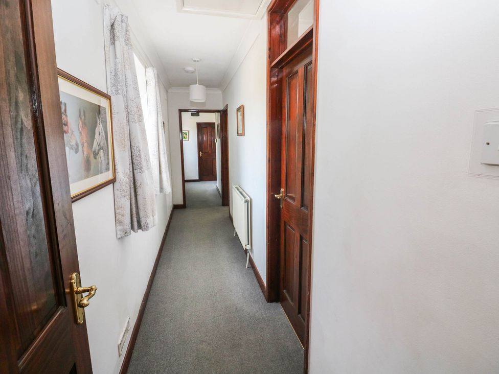 A hallway with doors and a radiator at Coedllys Uchaf Cottage