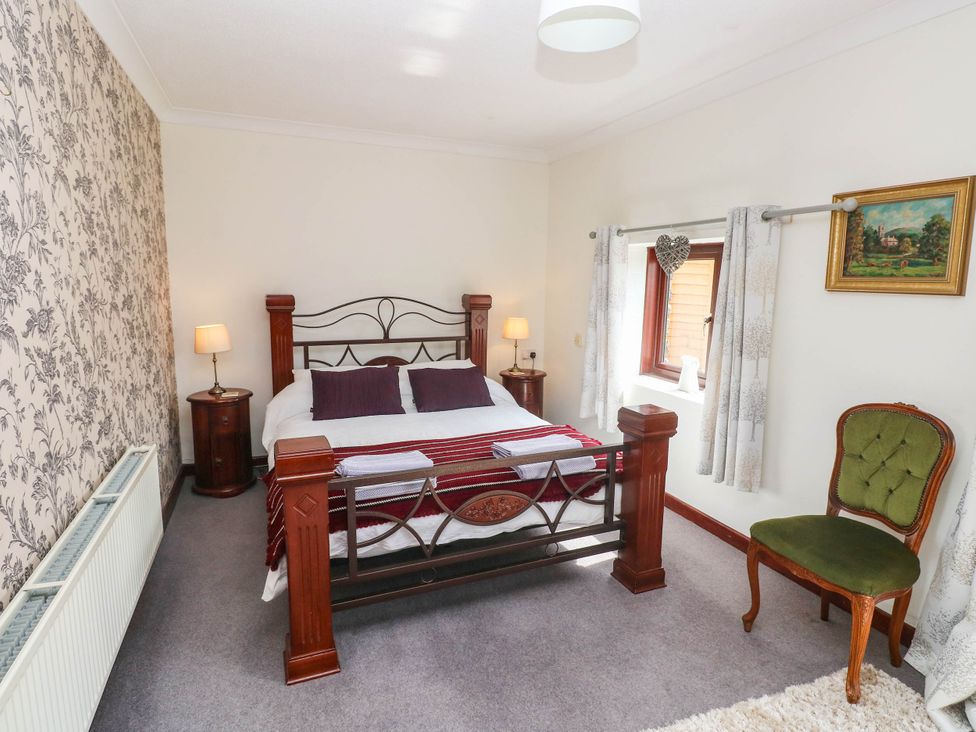 A bedroom with a bed and lamp at Coedllys Uchaf Cottage