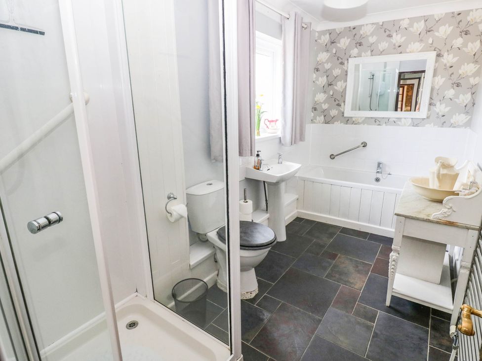 A bathroom with a shower, toilet, sink, and bathtub at Coedllys Uchaf Cottage