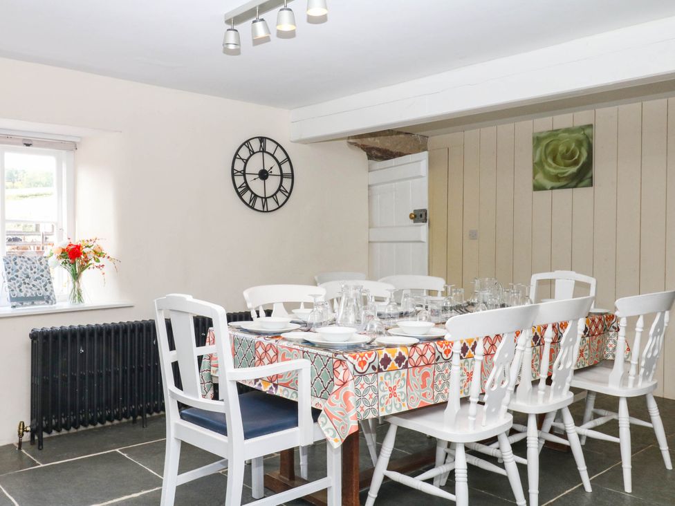 A dining room with a table set for a meal at The Cheese House near Charmouth