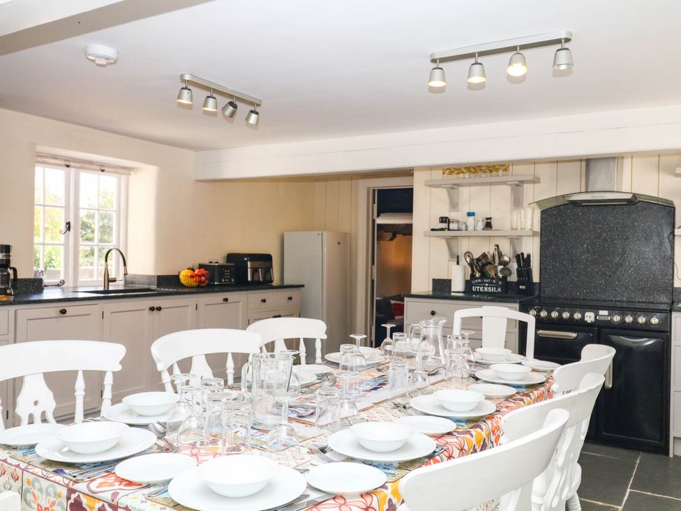 A kitchen with a dining table and chairs at The Cheese House near Charmouth