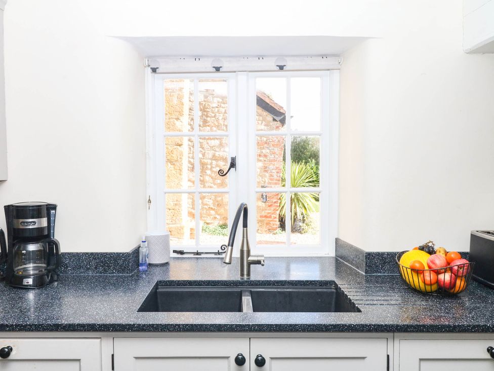 A kitchen with sink, coffee maker, and fruit bowl at The Cheese House near Charmouth