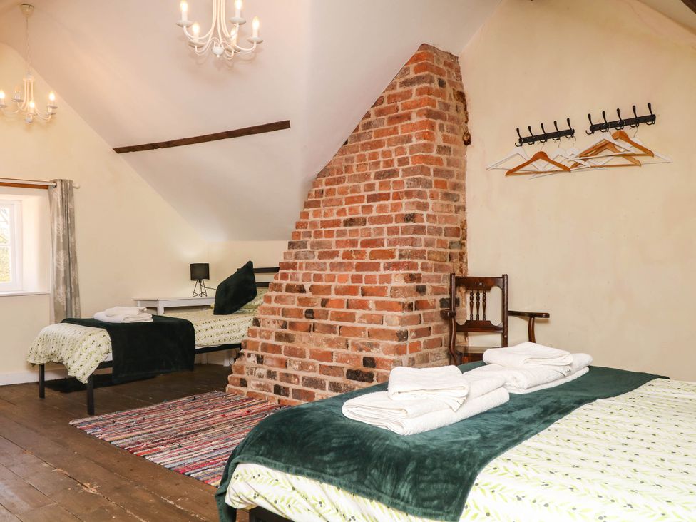 A bedroom with two beds and a window at The Cheese House near Charmouth
