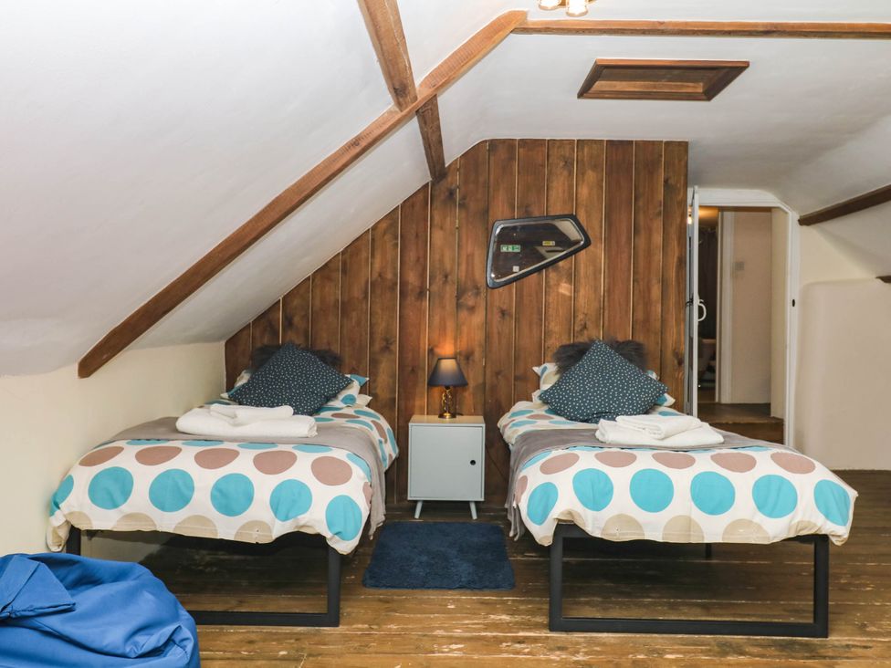 A bedroom with two single beds and a side table at The Cheese House near Charmouth