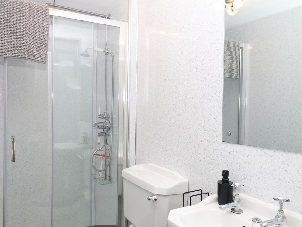 A bathroom with a shower, sink and toilet at The Cheese House near Charmouth