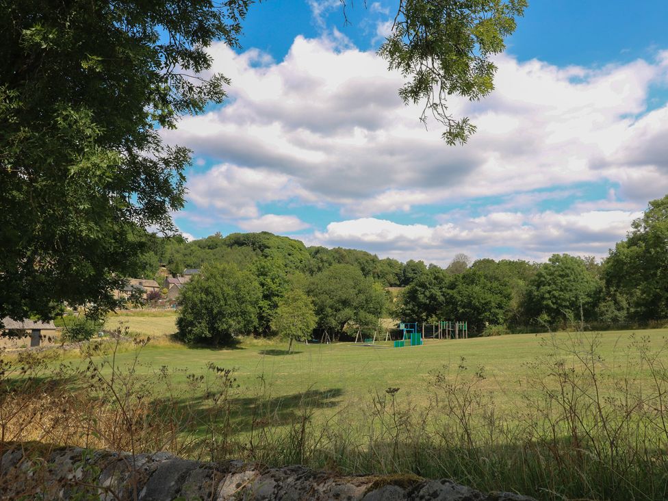A playground with a swing set in a grassy area at Birchover Chapel, Matlock
