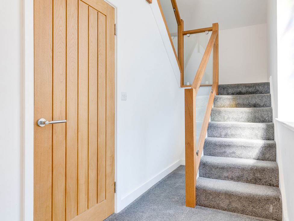 A hallway with a door and staircase at Birchover Chapel in Birchover