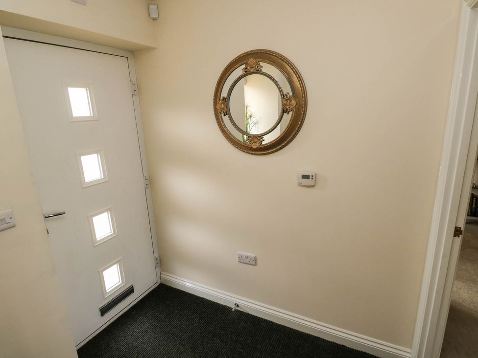 An entrance hall with a door and a mirror at Canal House in Shipley