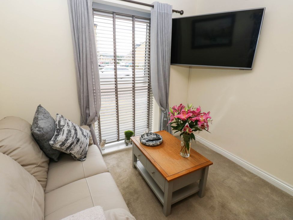 A living room with a sofa, coffee table, and television at Canal House in Shipley