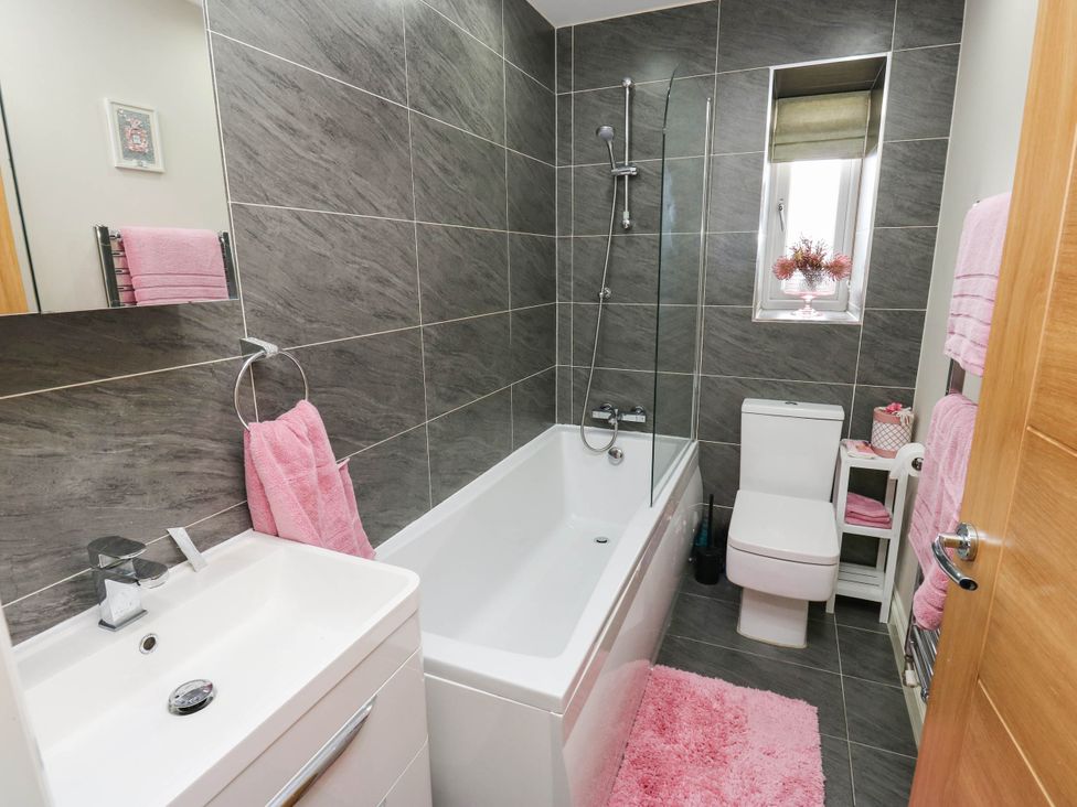 A bathroom with a bathtub, toilet and sink at Canal House in Shipley