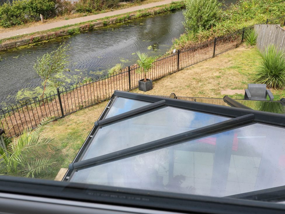 A view of a garden with water and plants at Canal House in Shipley