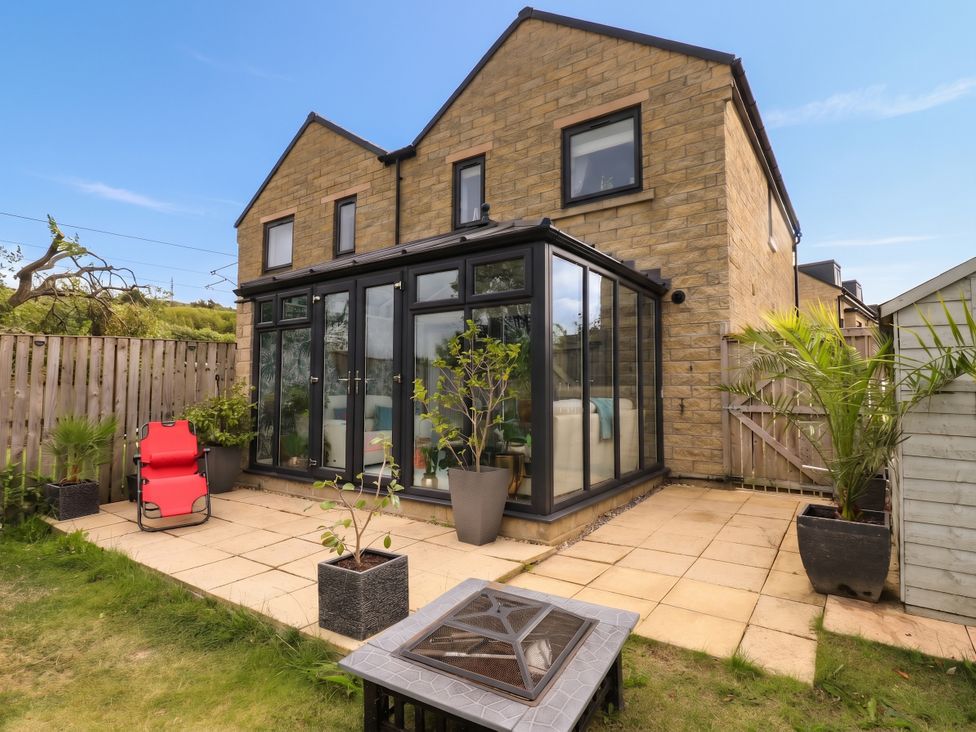 A garden with a glass conservatory at Canal House in Shipley
