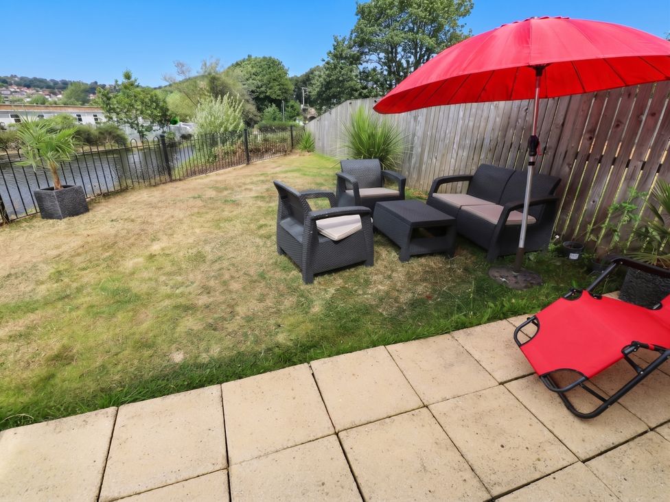 A garden with seating and an umbrella at Canal House in Shipley