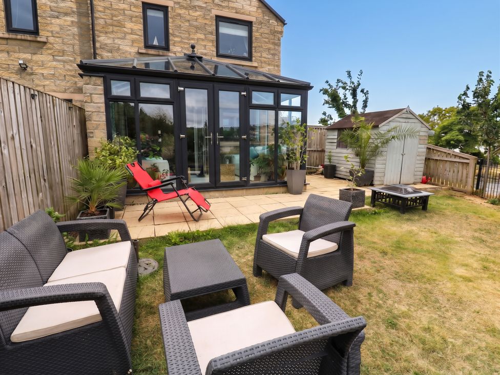 A garden with outdoor seating and a shed at Canal House Shipley