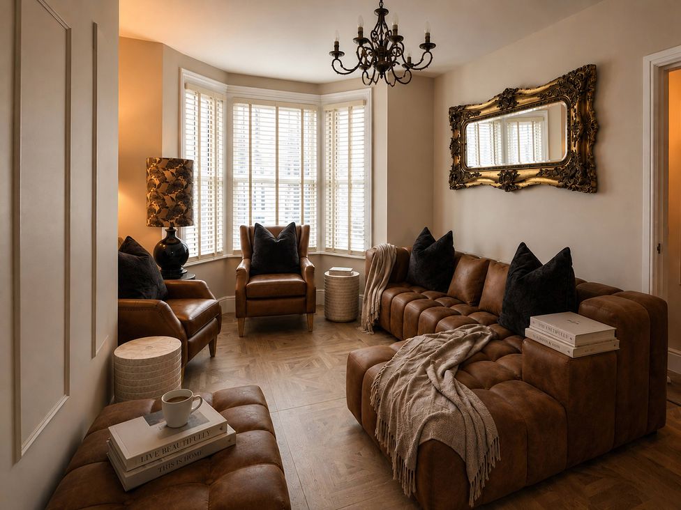 A living room with a leather sofa and armchairs at Number 8 Llandudno