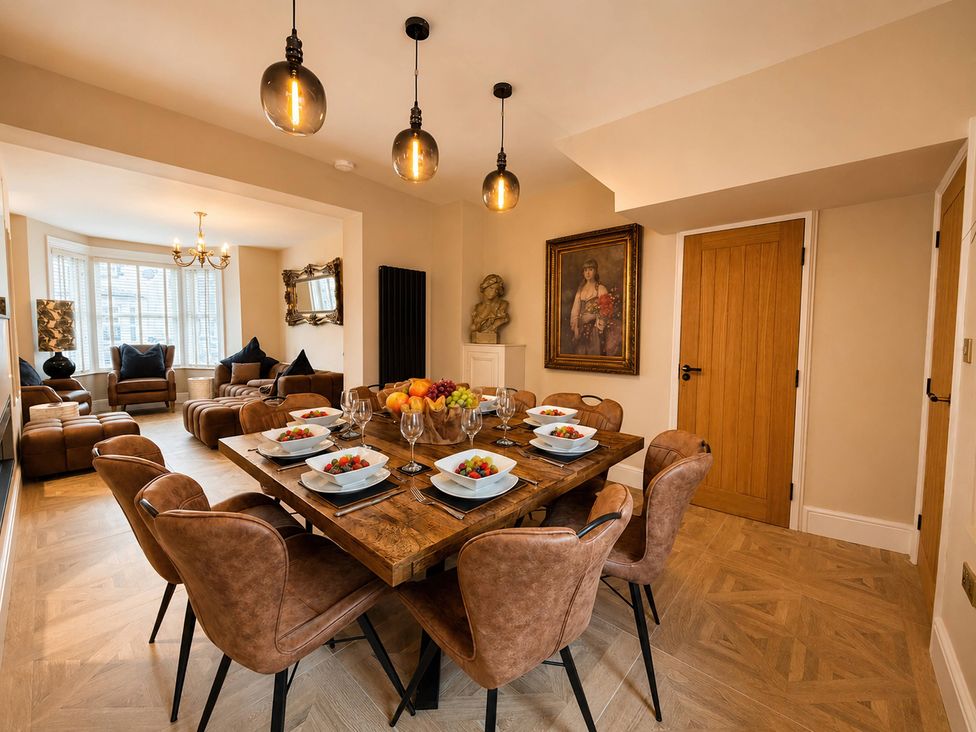 A dining room with a wooden dining table and chairs at Number 8 Llandudno