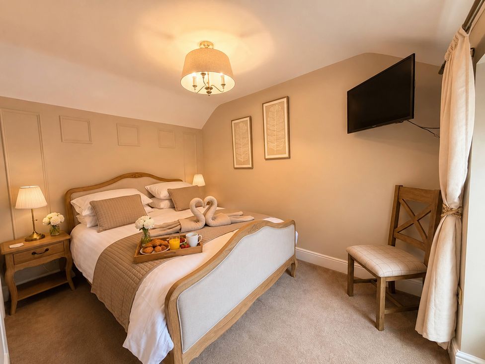 A bedroom with a bed and television at Number 8 Llandudno