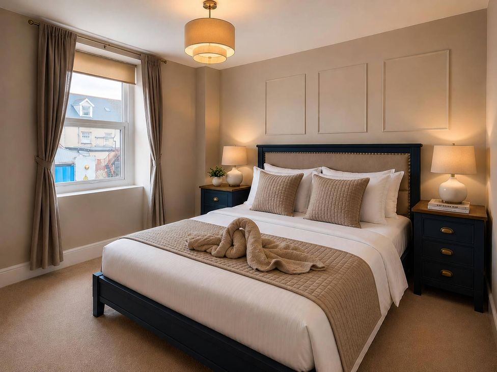 A bedroom with a bed and side tables at Number 8 in Llandudno