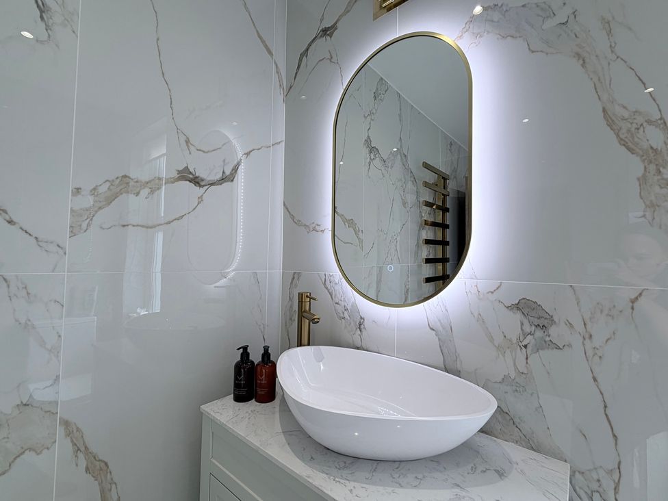 A bathroom with a basin and mirror at Number 8 Llandudno
