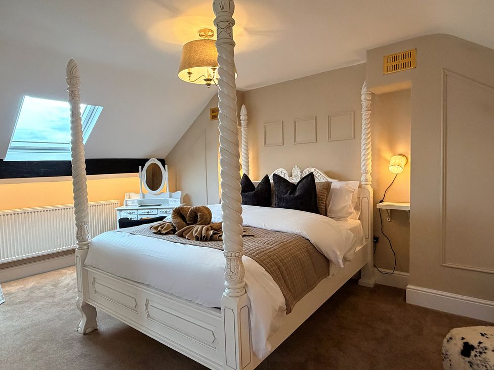 A bedroom with a four-poster bed and a dresser at Number 8 in Llandudno
