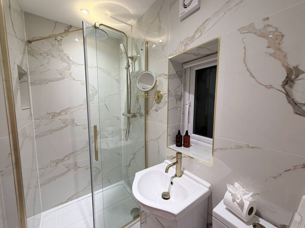 A bathroom with a shower and wash basin at Number 8 Llandudno