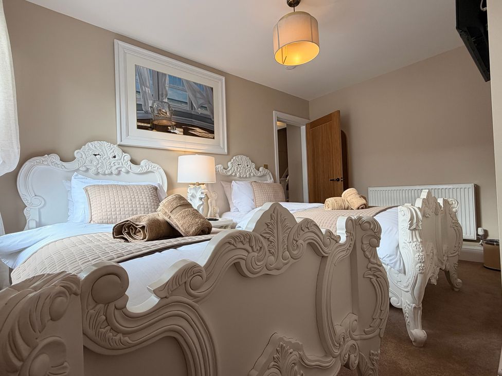 A bedroom with two beds and decorative items at Number 8 Llandudno