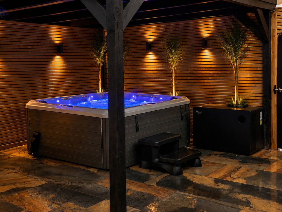 A hot tub with lighting and potted plants at Number 8, Llandudno