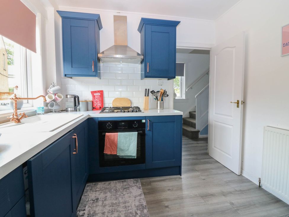 A kitchen with cabinets and appliances at 6 Niddrie Marischal Road in Edinburgh