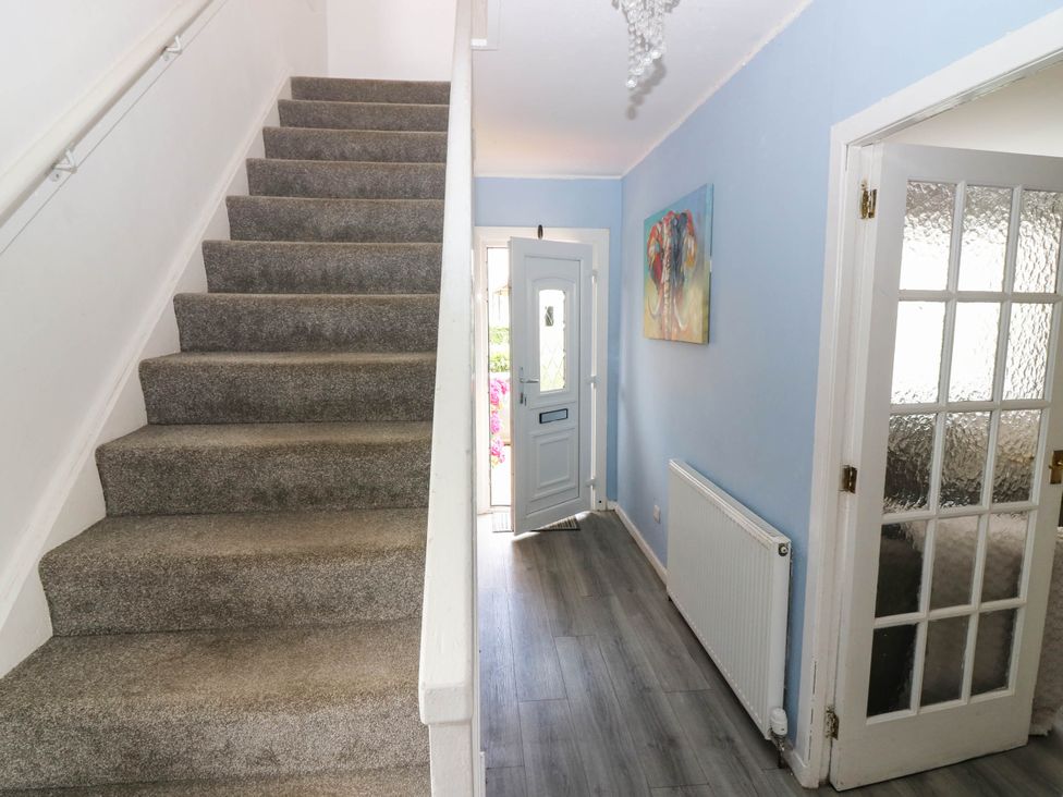 A hallway with a staircase and front door at 6 Niddrie Marischal Road, Edinburgh