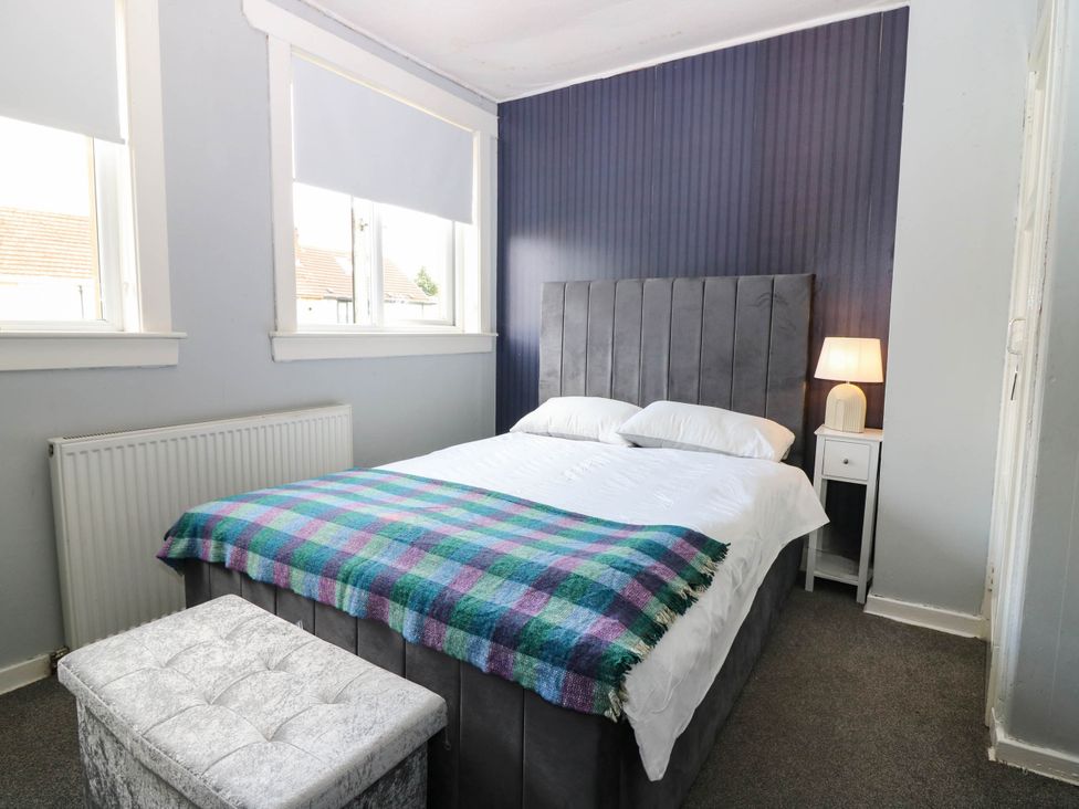 A bedroom with a bed and bedside table at 6 Niddrie Marischal Road in Edinburgh