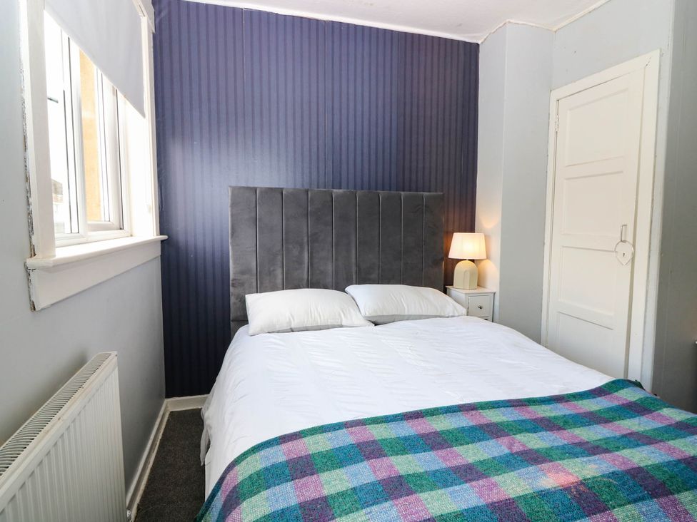 A bedroom with a bed and bedside table at 6 Niddrie Marischal Road, Edinburgh