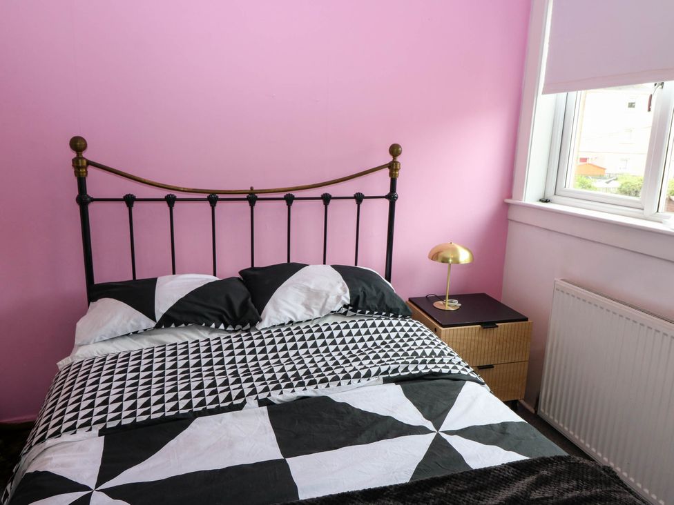A bedroom with a bed and bedside lamp at 6 Niddrie Marischal Road, Edinburgh