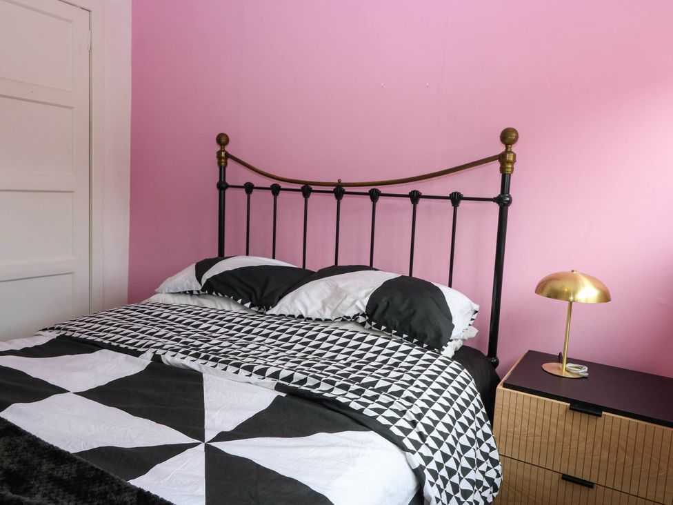 A bedroom with a bed and nightstand at 6 Niddrie Marischal Road, Edinburgh