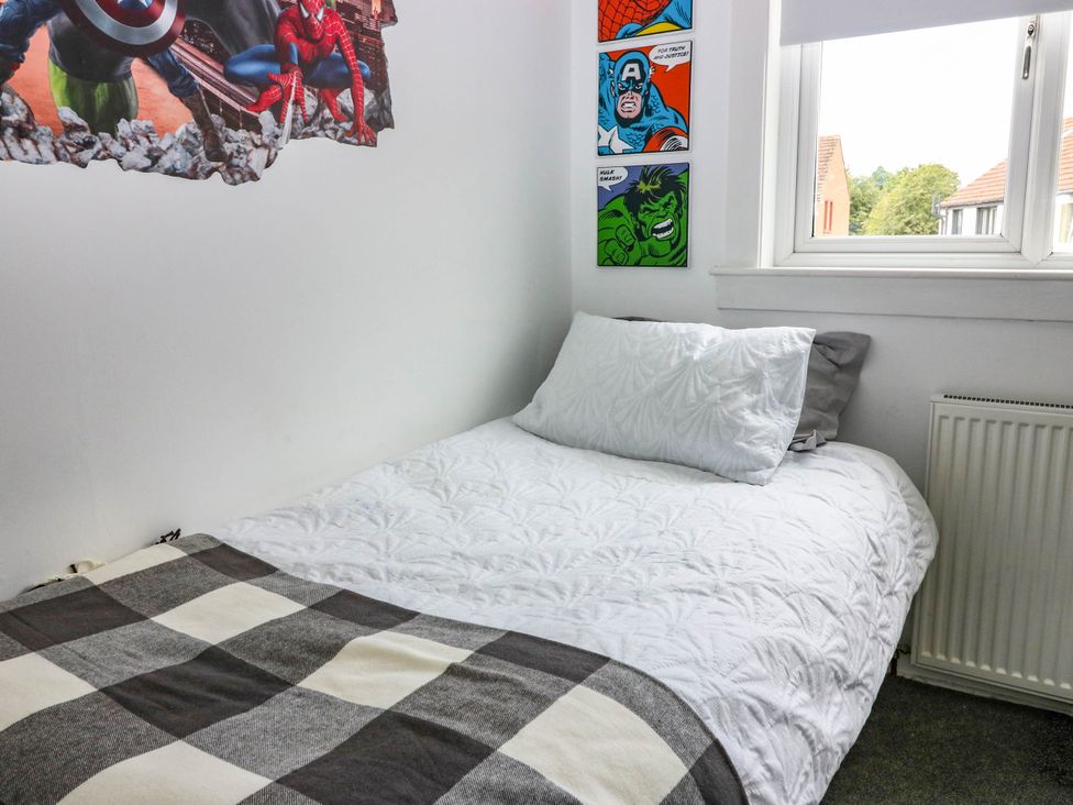 A bedroom with a bed and wall art at 6 Niddrie Marischal Road in Edinburgh