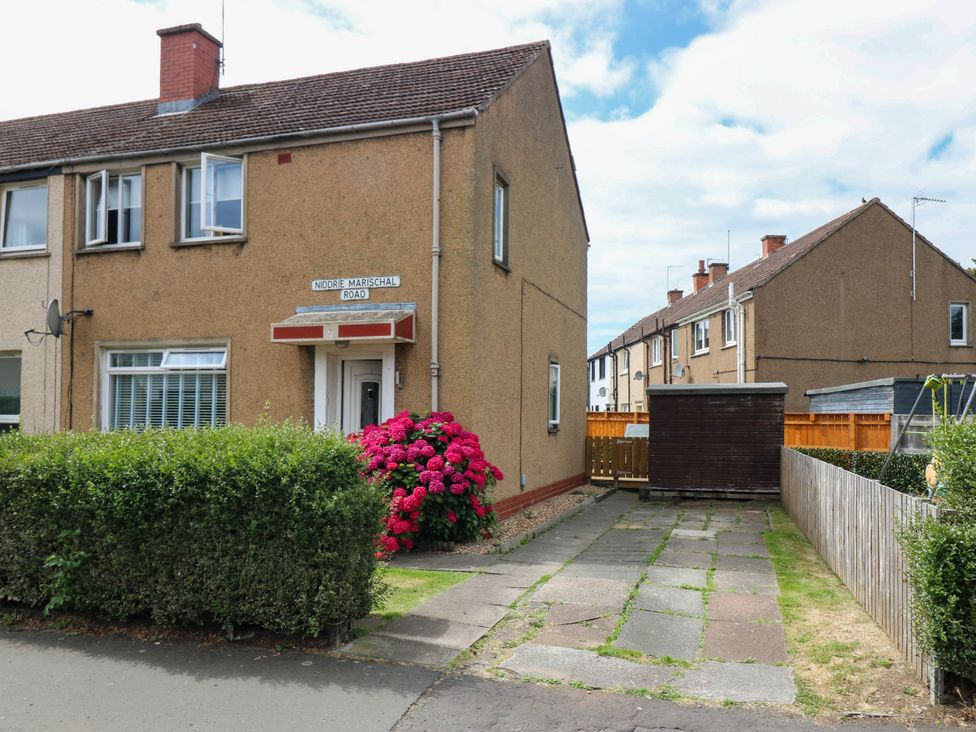 A house with flowers and a pathway at 6 Niddrie Marischal Road in Edinburgh