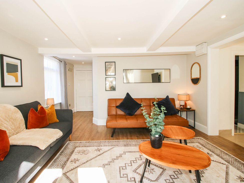 A living room with a sofa, coffee table, and plant at The Annex at The Lodge in Shawbury