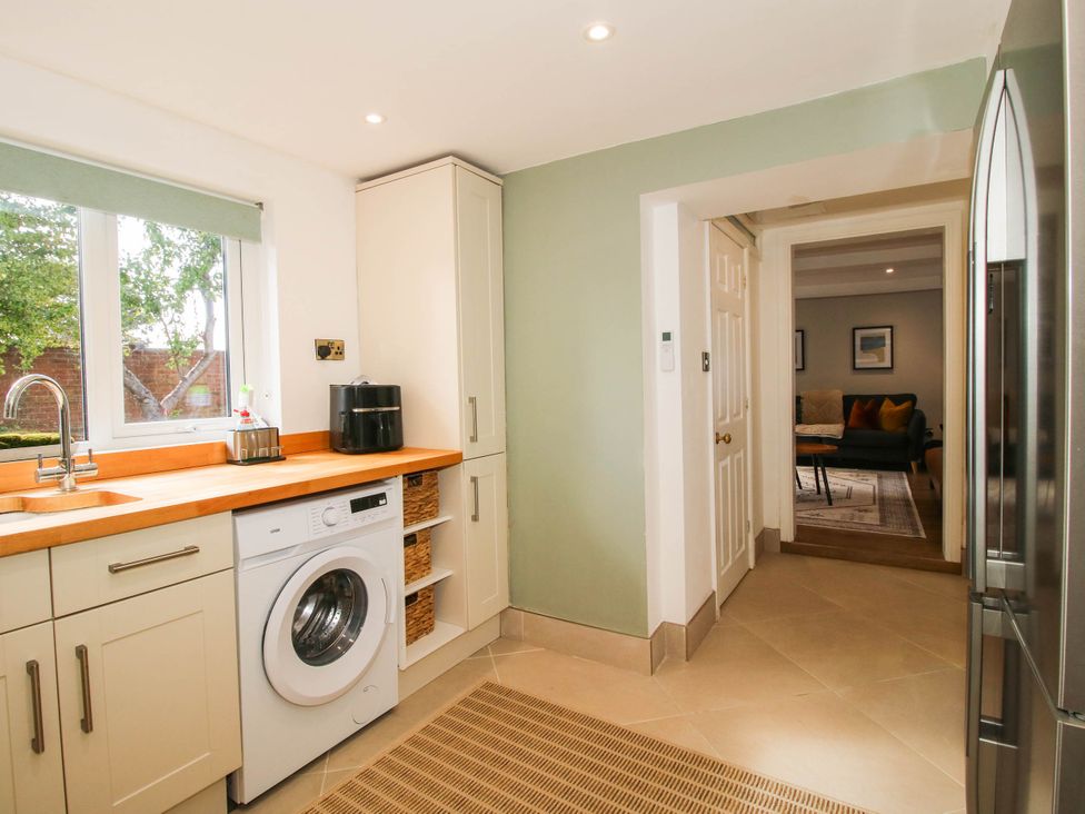 A kitchen with a washing machine and sink at The Annex at The Lodge Shawbury