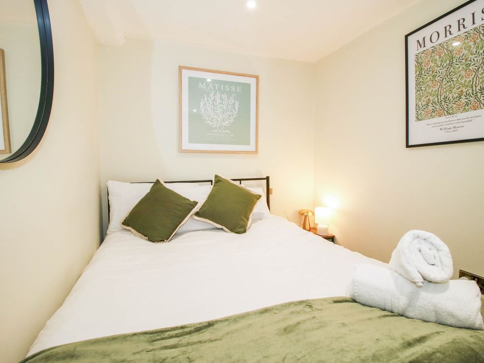 A bedroom with a bed and wall art at The Annex at The Lodge in Shawbury