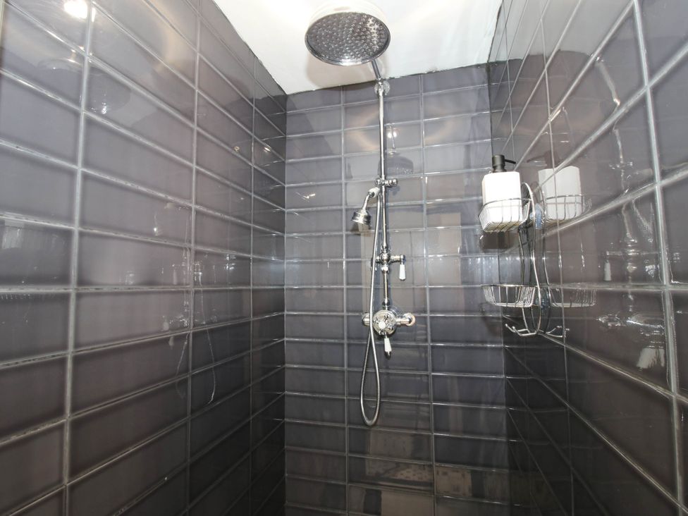 A shower with tiled walls and fixtures at The Annex at The Lodge Shawbury