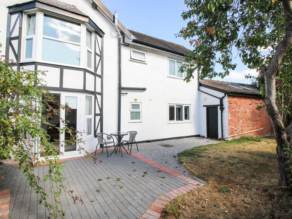 An outdoor area with a house, table, and chairs at The Annex at The Lodge in Shawbury