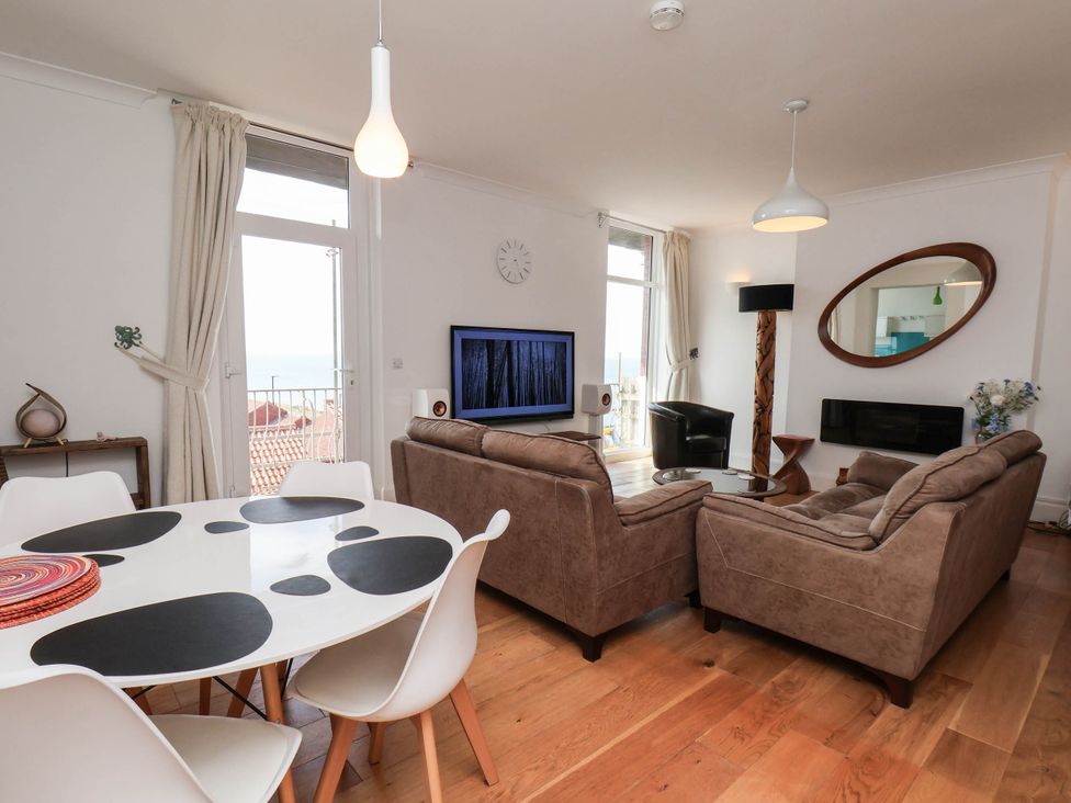 A living room with a sofa and dining table at 26 Metropole Towers in Whitby