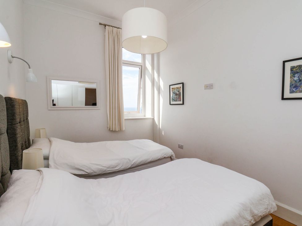 A bedroom with twin beds and a window at 26 Metropole Towers in Whitby