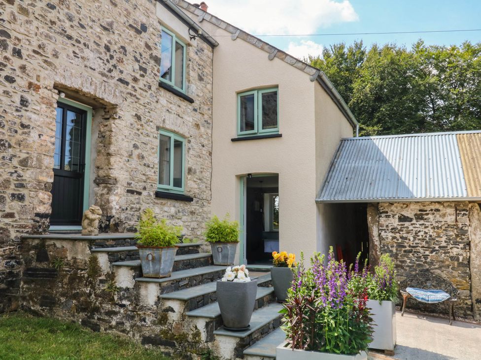 A house exterior with stone wall and planters at Little Moorgate Okehampton