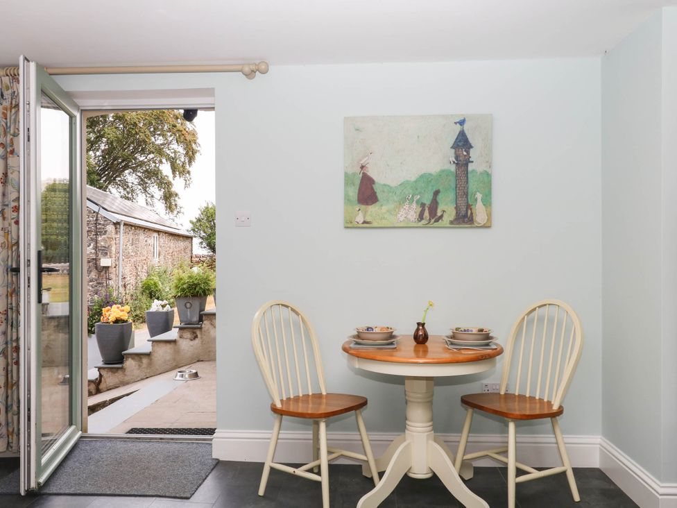 A dining room with a table and chairs at Little Moorgate in Okehampton