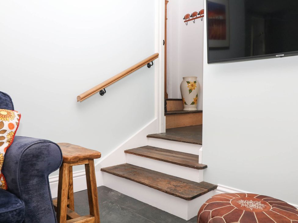 A staircase with a handrail and vase at Little Moorgate Okehampton