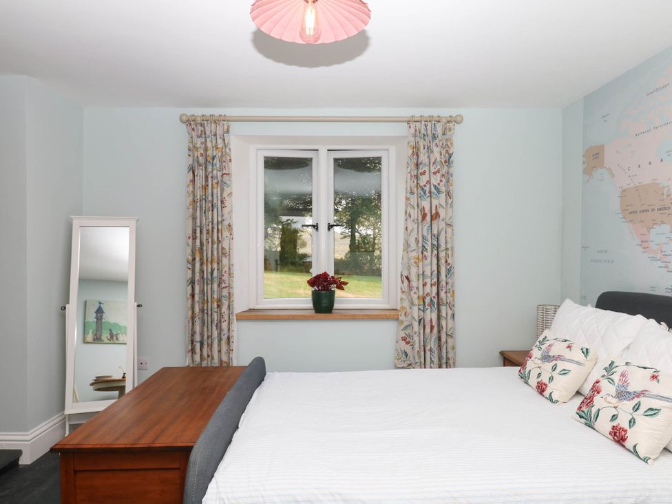 A bedroom with a bed and a window at Little Moorgate in Okehampton