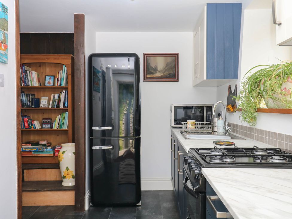 A kitchen featuring a refrigerator and bookshelf at Little Moorgate in Okehampton