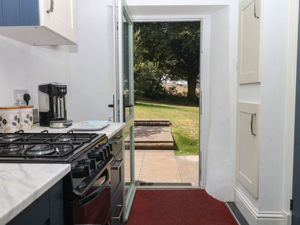 A kitchen with a gas stove and coffee maker at Little Moorgate in Okehampton
