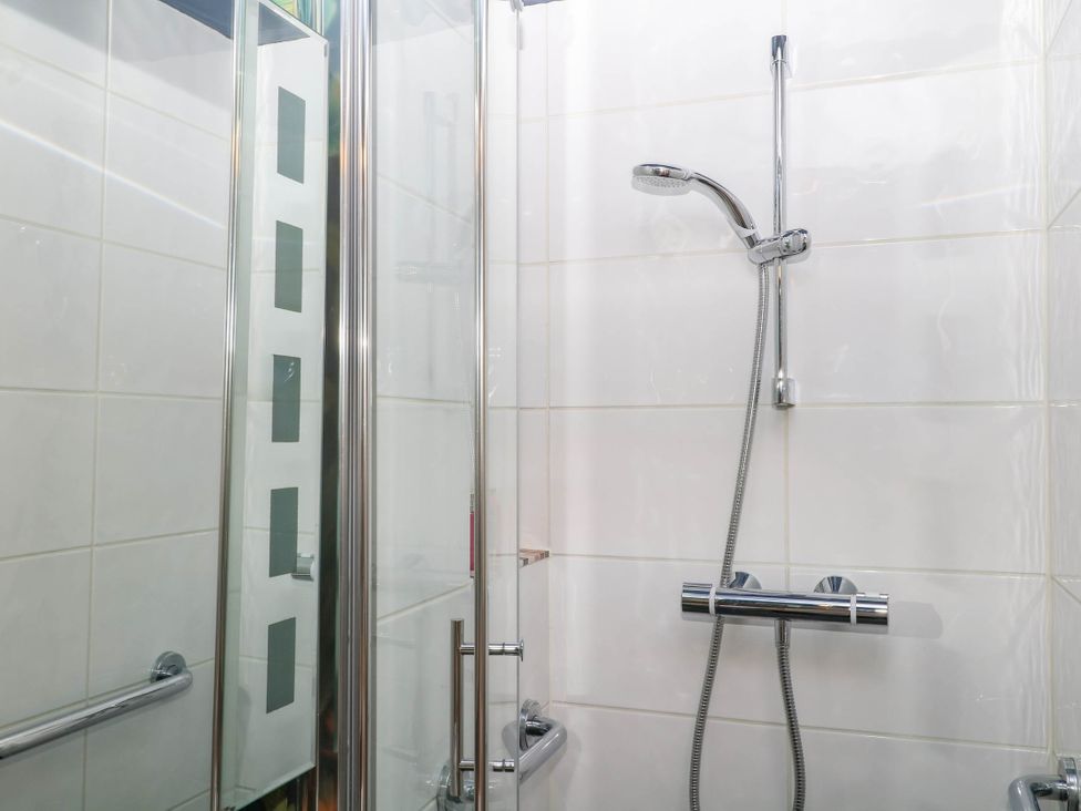 A shower with a glass door and chrome fixtures at Little Moorgate Okehampton